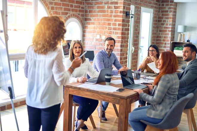 Group of business workers working together in a meeting. One of them making presentation to colleagues at the office