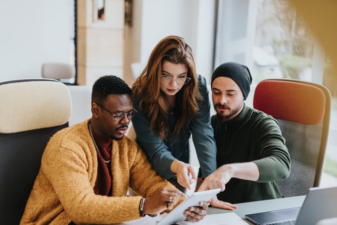 A team of diverse employees collaborating and discussing innovative solutions for business growth and profitability in a modern office environment.